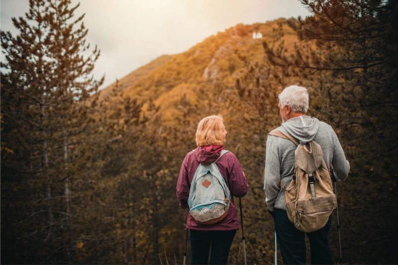 An older couple hiking through the woods